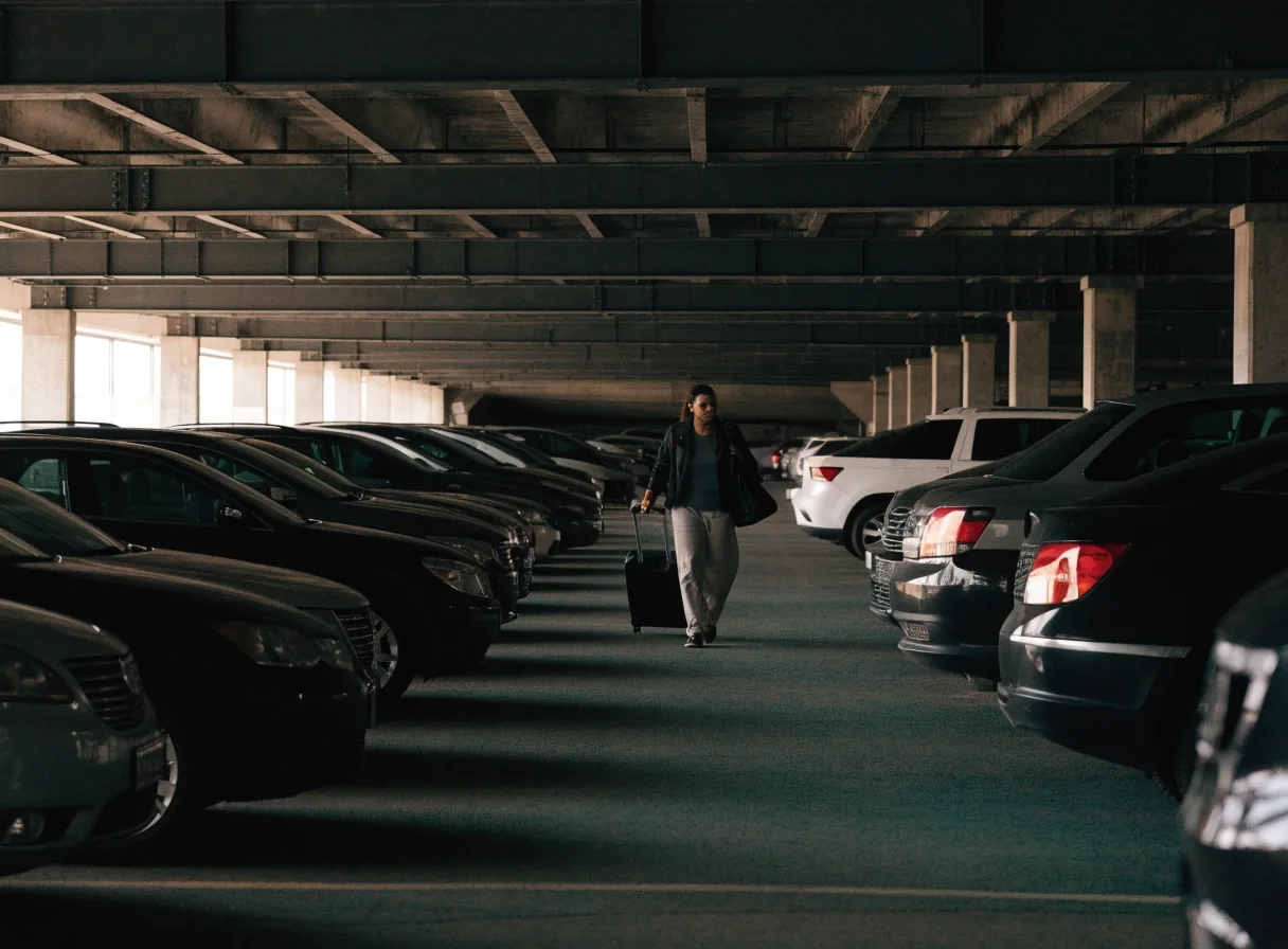 A parked car in a covered bay beneath a concrete slab at an airport car park