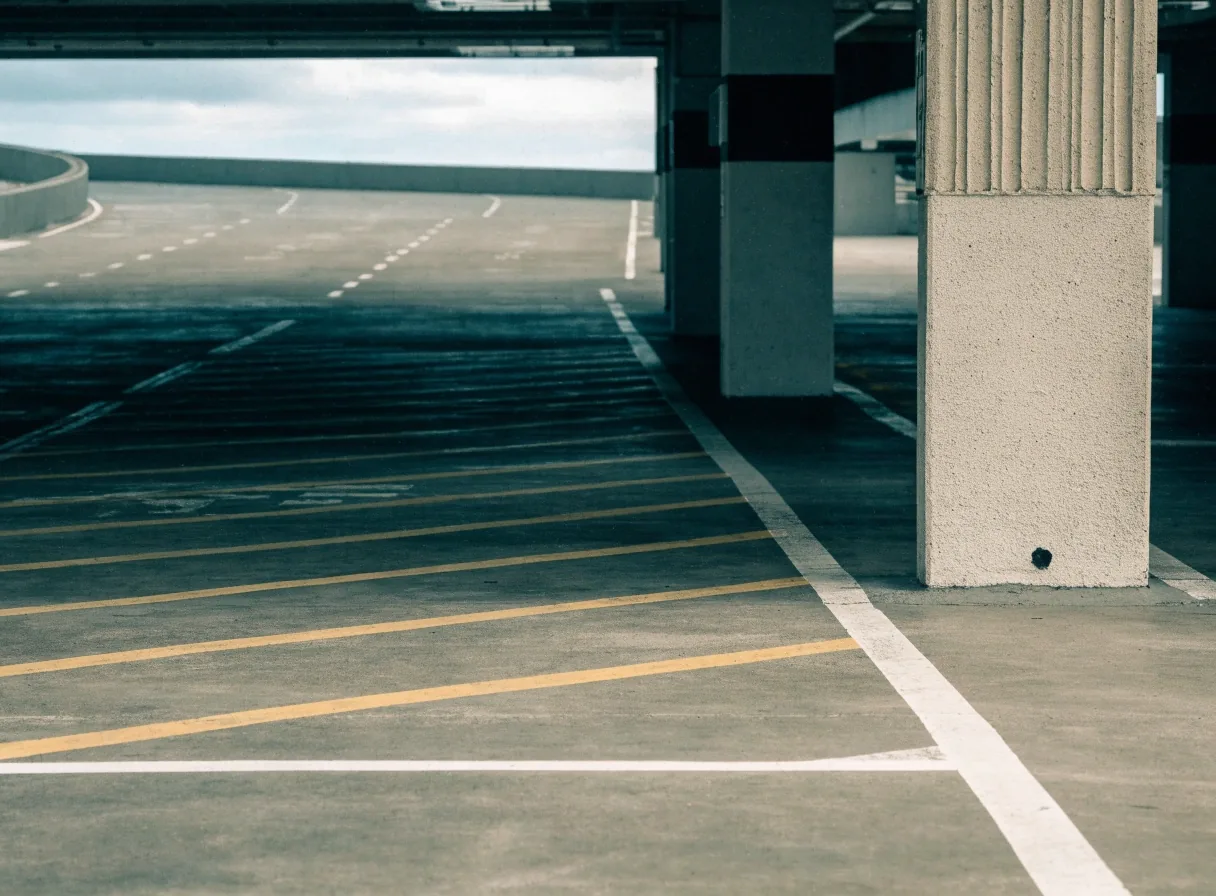 Undercover parking deck bay stripes and pillar at Brisbane Airport in flat overcast daylight